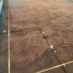 High-Gloss Amber Burl Wood Dining Table with Cream Quilted Leather Base and Metal Inlay